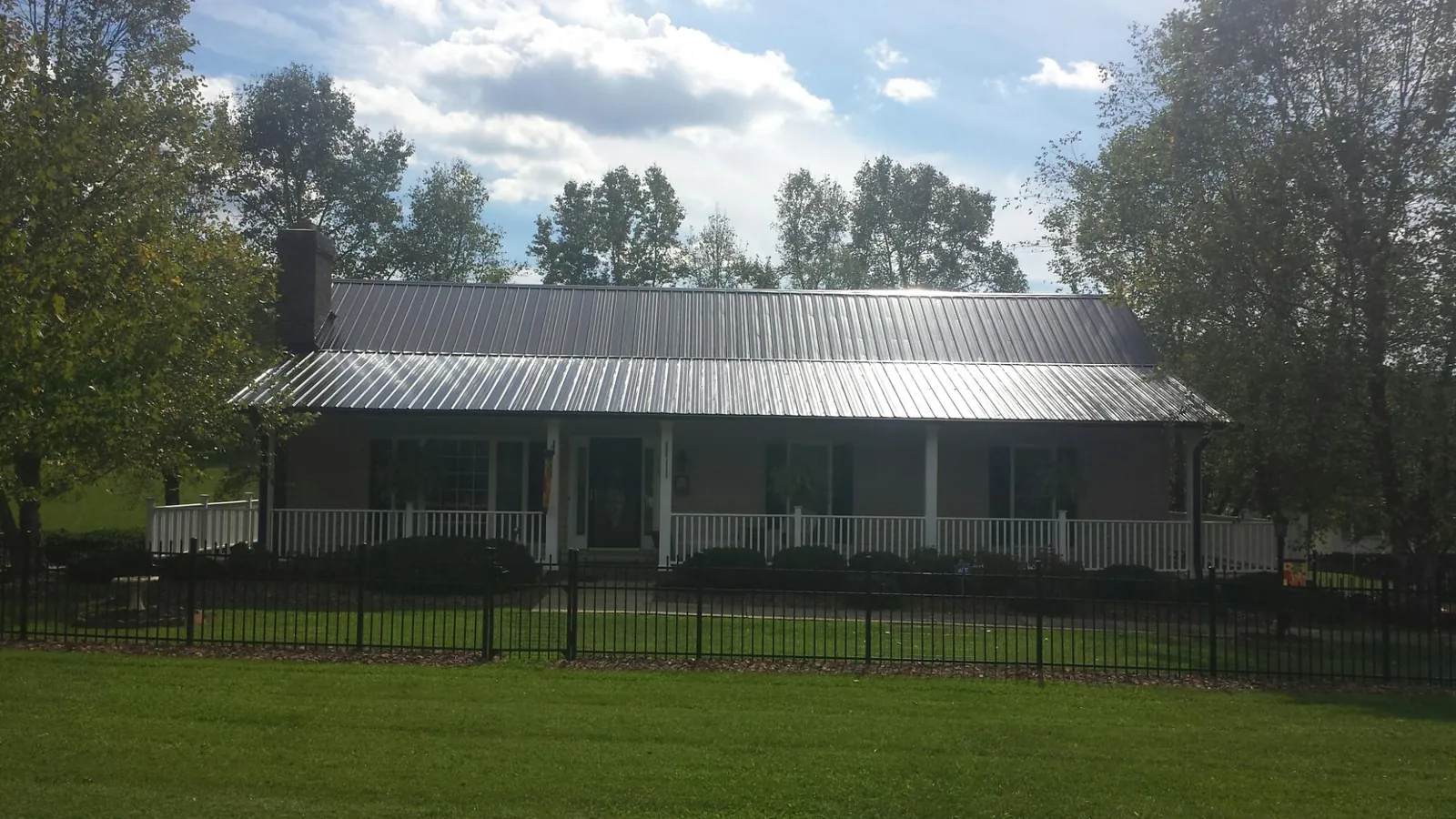 Gray metal roof on a brick ranch with a full width front porch — Gutter Guard Installation work by our crew in Nashville